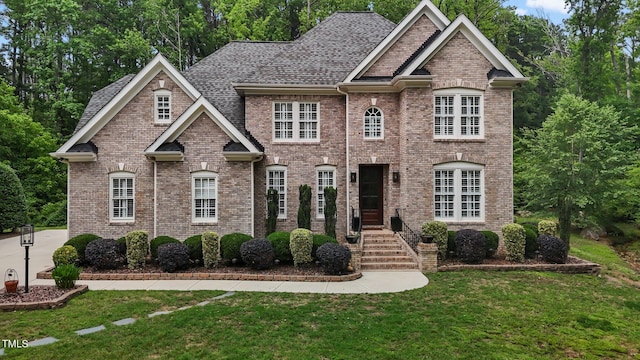 3323 Cheswick Dr, Raleigh, NC 27609 - view of front of home featuring brick siding, a front yard, and roof with shingles