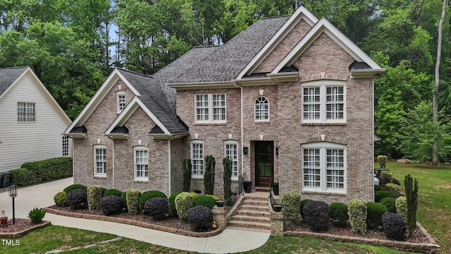 3323 Cheswick Dr, Raleigh, NC 27609 - view of front facade with brick siding, a front lawn, and roof with shingles