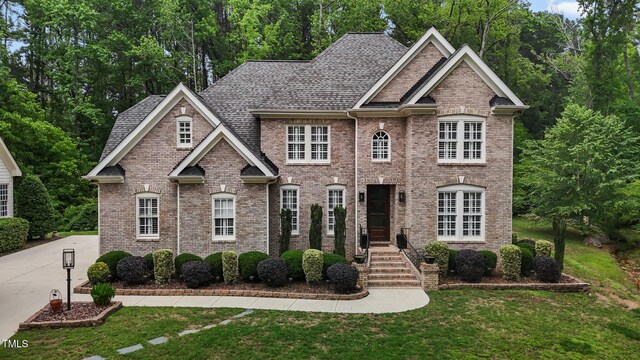 3323 Cheswick Dr, Raleigh, NC 27609 - view of front of home with brick siding, a front lawn, and a shingled roof