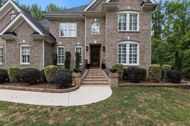 3323 Cheswick Dr, Raleigh, NC 27609 - colonial home with brick siding, a front yard, and roof with shingles