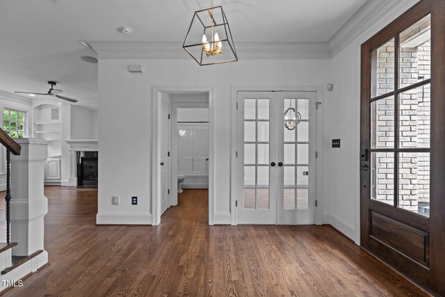 3323 Cheswick Dr, Raleigh, NC 27609 - foyer entrance with a chandelier, crown molding, wood finished floors, baseboards, and stairs