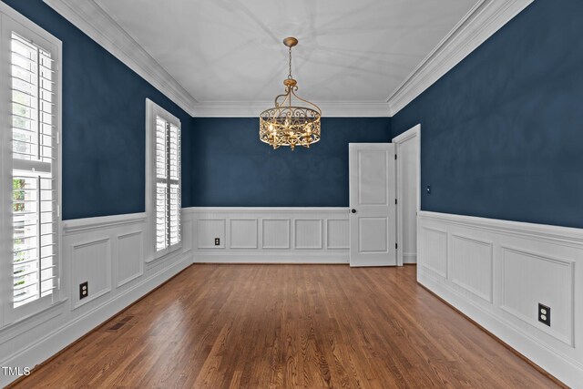 3323 Cheswick Dr, Raleigh, NC 27609 - spare room featuring a chandelier, wainscoting, wood finished floors, and crown molding