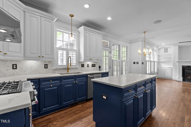 3323 Cheswick Dr, Raleigh, NC 27609 - kitchen with blue cabinetry, stainless steel appliances, range hood, a sink, and recessed lighting