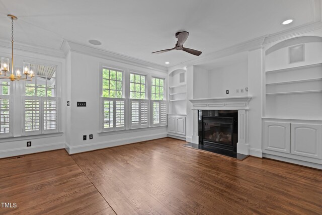 3323 Cheswick Dr, Raleigh, NC 27609 - unfurnished living room featuring ornamental molding, built in shelves, a chandelier, ceiling fan, and wood finished floors