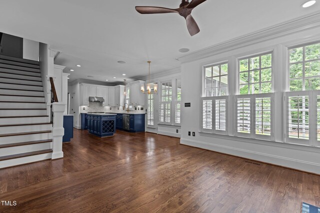 3323 Cheswick Dr, Raleigh, NC 27609 - unfurnished living room with ceiling fan, stairs, ornamental molding, dark wood finished floors, and a chandelier