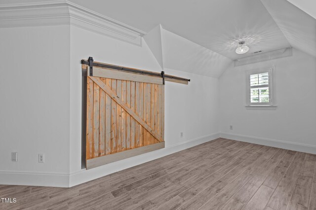 3323 Cheswick Dr, Raleigh, NC 27609 - additional living space with wood finished floors, lofted ceiling, baseboards, and a barn door