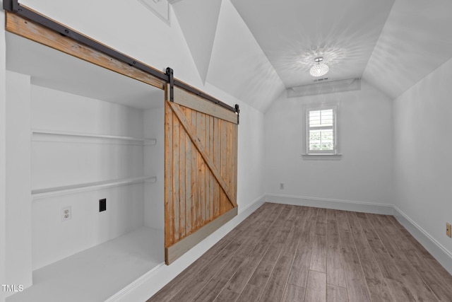3323 Cheswick Dr, Raleigh, NC 27609 - bonus room with wood finished floors, a barn door, lofted ceiling, and baseboards