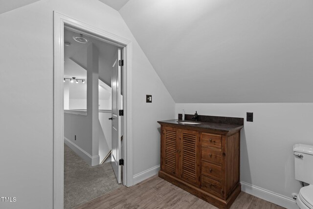 3323 Cheswick Dr, Raleigh, NC 27609 - bathroom with vaulted ceiling, toilet, wood finished floors, a sink, and baseboards