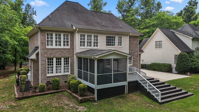 3323 Cheswick Dr, Raleigh, NC 27609 - rear view of property featuring a sunroom, brick siding, a yard, and roof with shingles
