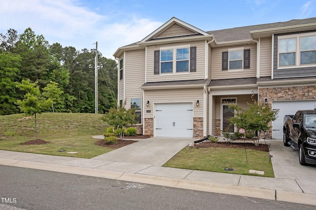view of front of property with a front lawn, stone siding, concrete driveway, and an attached garage