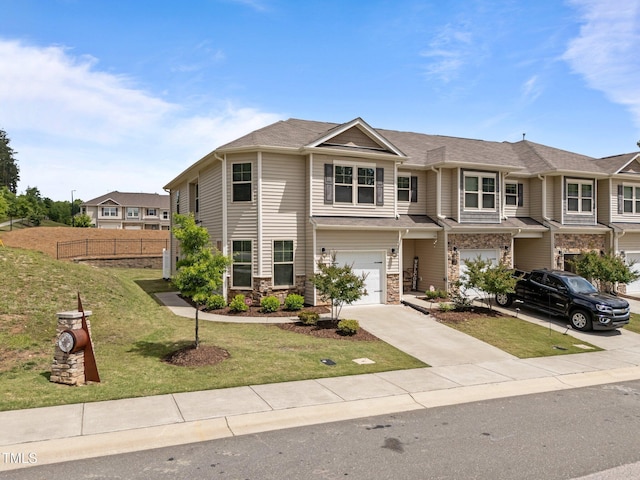 townhome / multi-family property with driveway, a garage, and stone siding