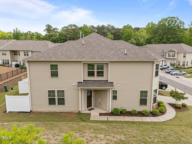 rear view of property with a shingled roof