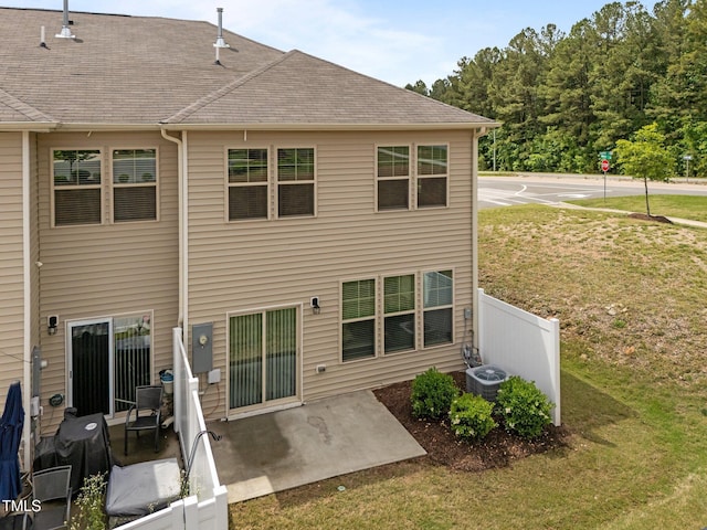 rear view of house featuring a patio, central air condition unit, and a shingled roof