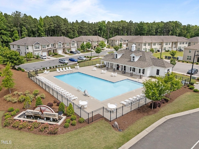 community pool with fence, a residential view, and a patio