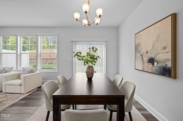 dining space with a chandelier, dark wood-style floors, and baseboards