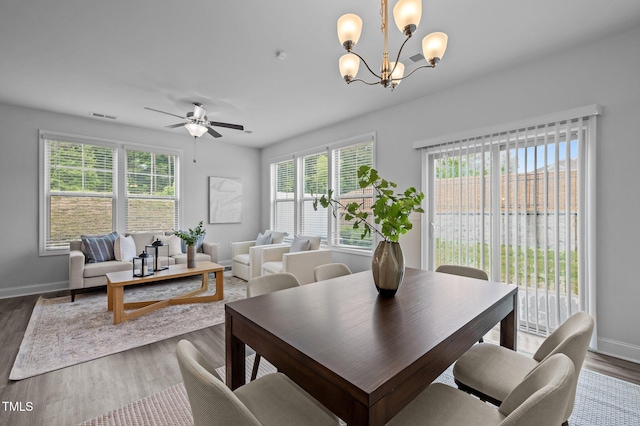 dining room featuring a chandelier, wood finished floors, and baseboards
