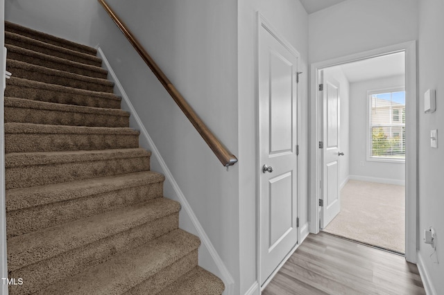 stairway with wood finished floors and baseboards