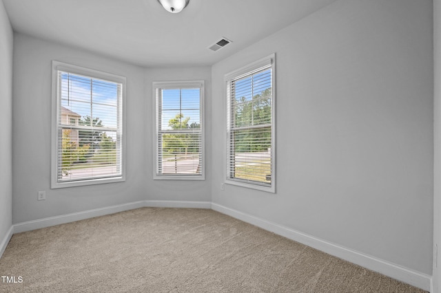 carpeted empty room featuring baseboards