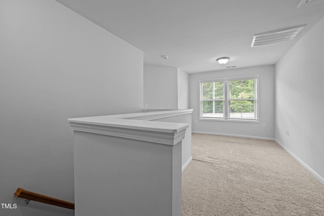empty room with baseboards and light colored carpet