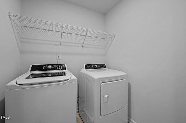 laundry room featuring washing machine and dryer and baseboards