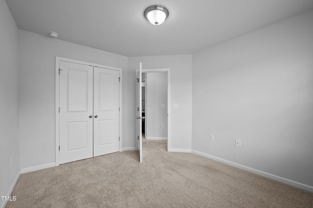 unfurnished bedroom featuring carpet flooring, a closet, and baseboards