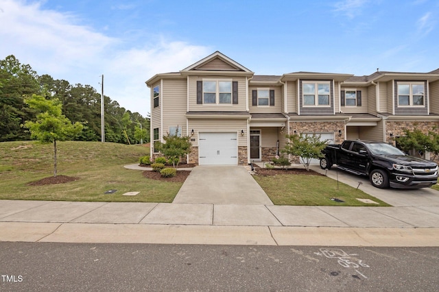 multi unit property featuring a garage, driveway, a front yard, and stone siding