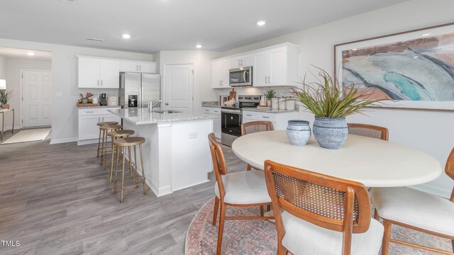 209 Wood St, La Grange, NC 28551 - kitchen featuring appliances with stainless steel finishes, a sink, white cabinets, light wood finished floors, and recessed lighting