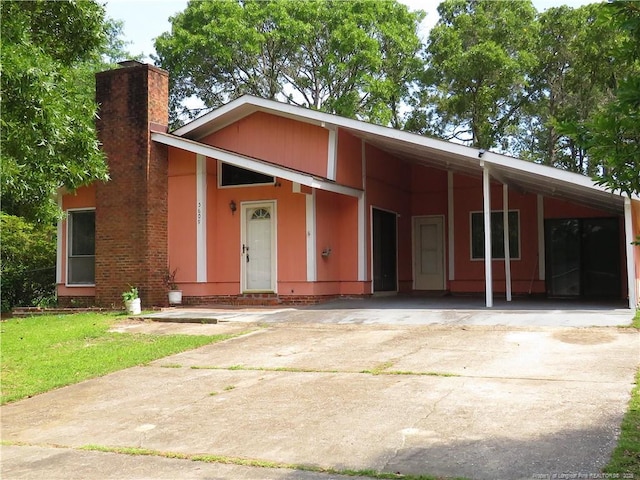 5609 Bowman Ct, Fayetteville, NC 28304 - mid-century inspired home featuring a carport, a chimney, driveway, and a front lawn