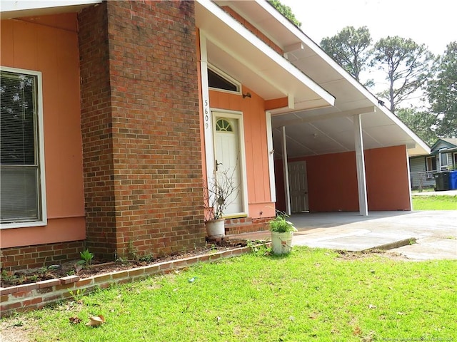 5609 Bowman Ct, Fayetteville, NC 28304 - view of exterior entry with a lawn, an attached carport, and driveway