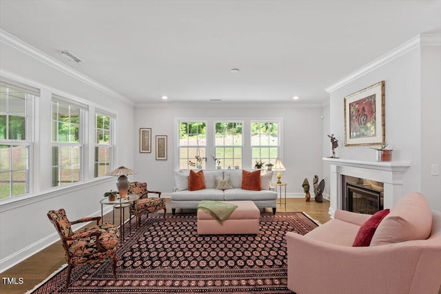 131 English Violet Ln, Raleigh, NC 27610 - living area with a glass covered fireplace, wood finished floors, baseboards, ornamental molding, and recessed lighting