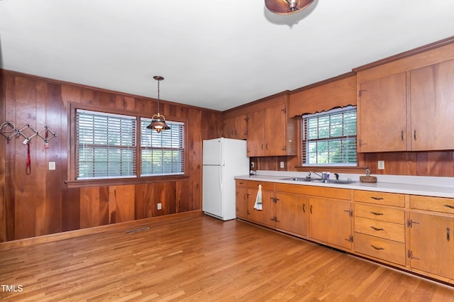 411 W Killiegrey St, Lillington, NC 27546 - kitchen featuring freestanding refrigerator, a sink, light countertops, light wood-style floors, and wood walls