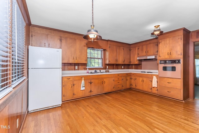 411 W Killiegrey St, Lillington, NC 27546 - kitchen with white appliances, under cabinet range hood, light wood-type flooring, light countertops, and brown cabinets