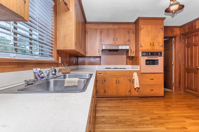 411 W Killiegrey St, Lillington, NC 27546 - kitchen with white appliances, a sink, light countertops, light wood-style flooring, and brown cabinets