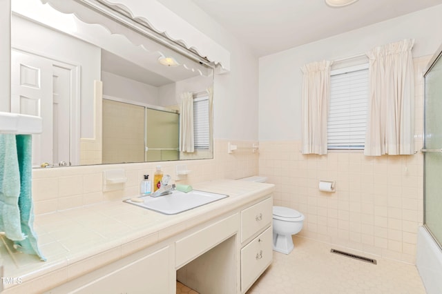 411 W Killiegrey St, Lillington, NC 27546 - full bathroom featuring an enclosed shower, toilet, vanity, a wainscoted wall, and tile walls
