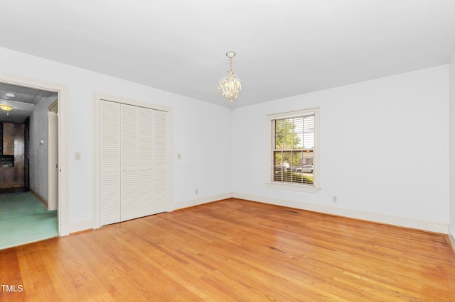 411 W Killiegrey St, Lillington, NC 27546 - unfurnished bedroom with light wood-style floors, baseboards, a chandelier, and a closet