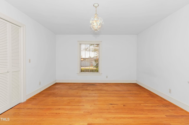411 W Killiegrey St, Lillington, NC 27546 - unfurnished bedroom featuring a chandelier, light wood-type flooring, baseboards, and a closet