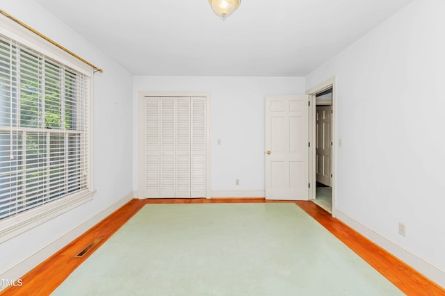 411 W Killiegrey St, Lillington, NC 27546 - unfurnished bedroom with wood finished floors, baseboards, and a closet