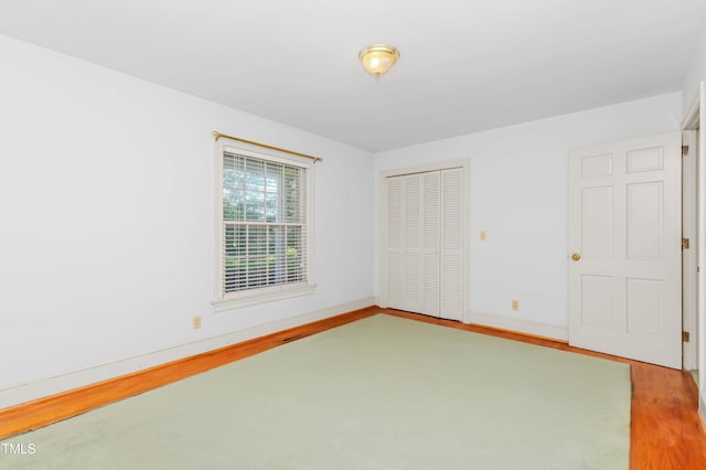 411 W Killiegrey St, Lillington, NC 27546 - unfurnished bedroom featuring wood finished floors, a closet, and baseboards