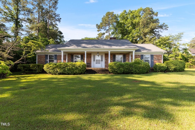 411 W Killiegrey St, Lillington, NC 27546 - view of front of property with a front lawn, brick siding, a porch, and a chimney