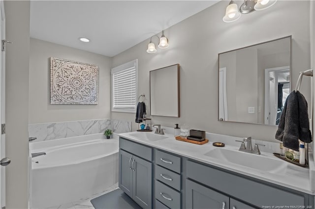 bathroom featuring marble finish floors, double vanity, and a bath