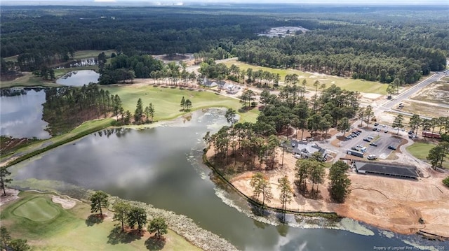 aerial view of property and surrounding area featuring a forest, a large body of water, and a golf club
