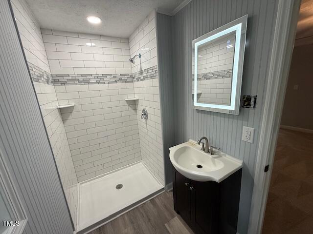 65 Prospect Church Rd, Erwin, NC 28339 - full bath featuring wood finished floors, a stall shower, vanity, crown molding, and a textured ceiling