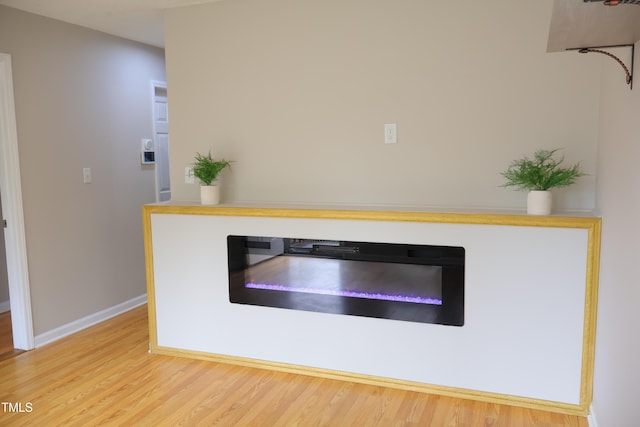 1536 Granville St, Burlington, NC 27215 - detailed view of a glass covered fireplace, wood finished floors, and baseboards