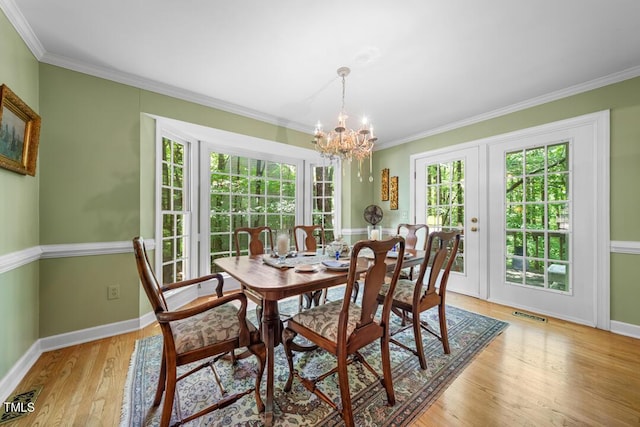4 Barkridge Ct, Durham, NC 27713 - dining room featuring plenty of natural light, light wood-type flooring, baseboards, a chandelier, and crown molding