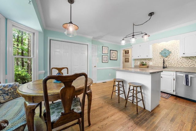 4 Barkridge Ct, Durham, NC 27713 - kitchen featuring stainless steel dishwasher, a sink, a center island, white cabinets, and decorative backsplash