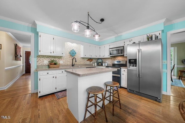 4 Barkridge Ct, Durham, NC 27713 - kitchen featuring appliances with stainless steel finishes, a sink, white cabinets, ornamental molding, and backsplash