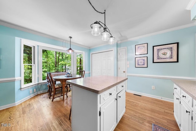 4 Barkridge Ct, Durham, NC 27713 - kitchen featuring white cabinetry, healthy amount of natural light, baseboards, and ornamental molding