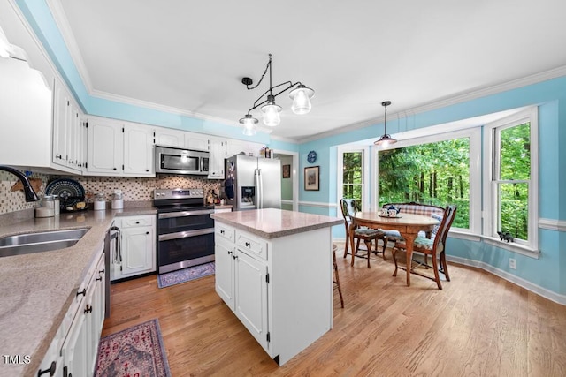 4 Barkridge Ct, Durham, NC 27713 - kitchen with stainless steel appliances, a sink, ornamental molding, backsplash, and white cabinets