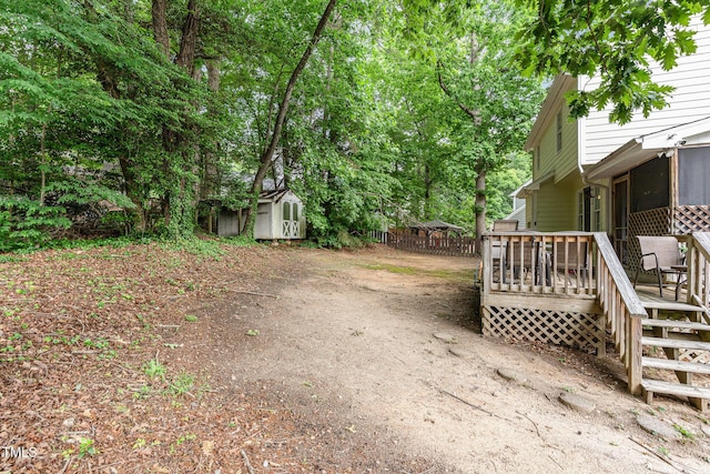 view of yard with a storage unit, a deck, and an outbuilding