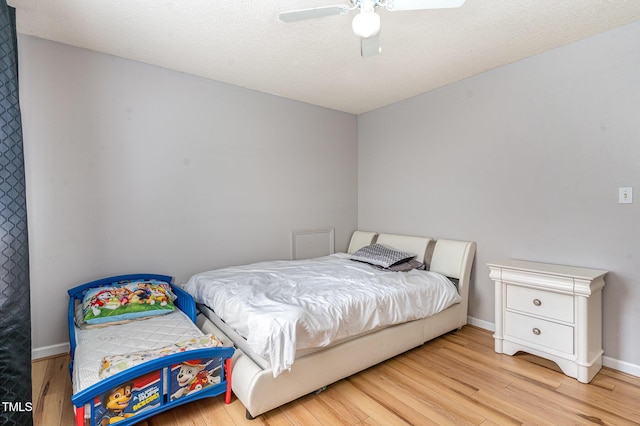 bedroom featuring light wood-style floors, baseboards, and ceiling fan